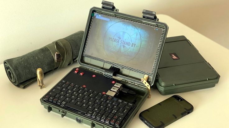 an open laptop computer sitting on top of a table next to other electronic devices and gadgets