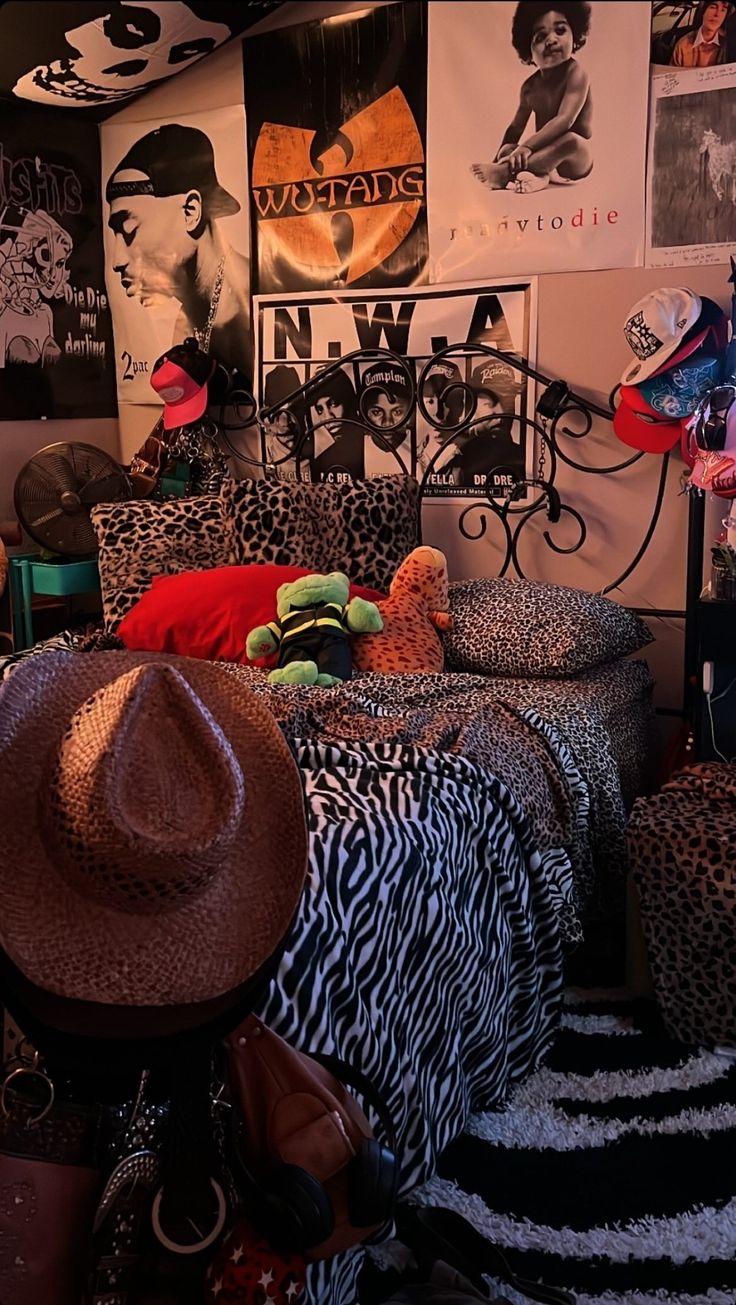 a bedroom with animal print bedding and hats on the headboard, walls covered in posters