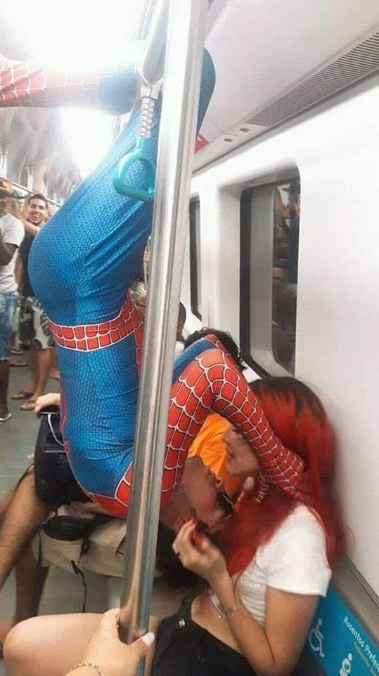 a woman dressed as spiderman on a subway train