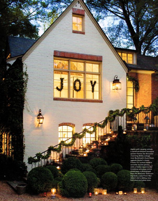 a white house with the words joy lit up at night on it's front porch