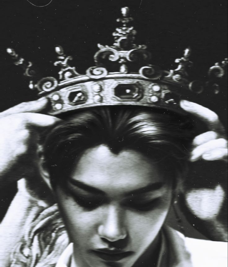 black and white photograph of a man with a crown on his head, looking down