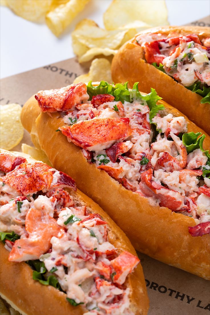 two lobster sandwiches with chips on the side