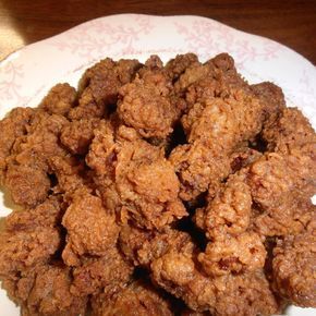 a white plate topped with fried food on top of a wooden table