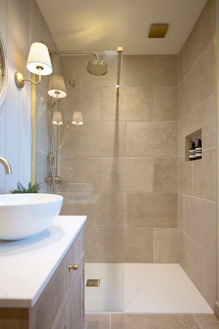 a white sink sitting under a bathroom mirror next to a walk in shower