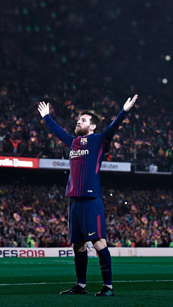 a man standing on top of a soccer field holding his hands up in the air