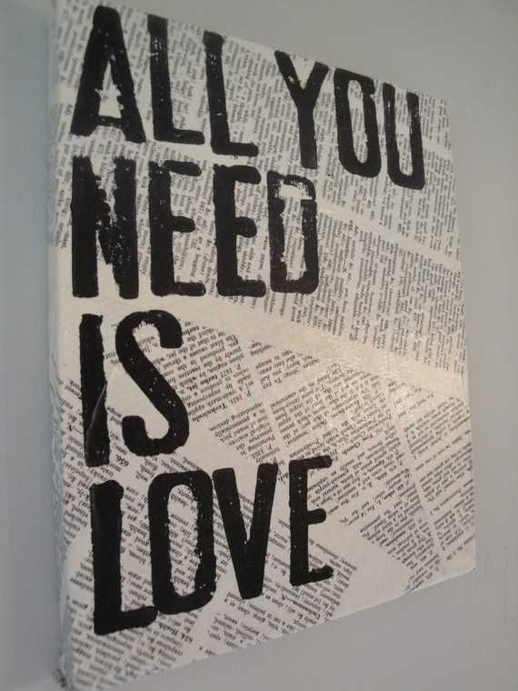 the words all you need is love are displayed on a piece of newspaper