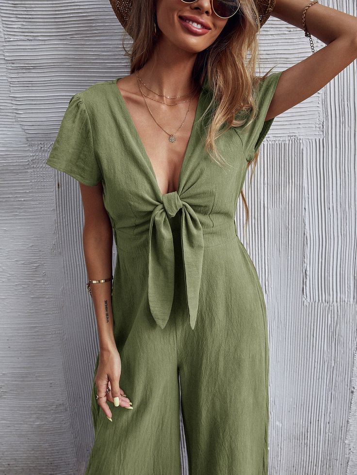 Our Tommy Bow Jumpsuit comes in a gorgeous army green tone in a relaxed fit. The low v neckline and front breast tie cinches in the figure. This comfortable jumpsuit is a must-have for every summer wardrobe. Size Guide: Lisa S is 5'6"tall, and has a 33.6"bust,24.2"waist,38.1"hips. She is wearing a S / US4 / AU8. This jumpsuit is true to size. Material: 65% Linen, 35% Viscose Feature: Wide-leg pants. Relaxed fit. Low V neckline. Tie bow on front. Maternity friendly. Care Instructions: Machine was Chic Green V-neck Jumpsuit, Green V-neck Jumpsuits And Rompers For Spring, Spring Green V-neck Jumpsuits And Rompers, Green V-neck Casual Jumpsuits And Rompers, Green V-neck Jumpsuits And Rompers For Summer, Green V-neck Jumpsuit For Summer, Casual Green Jumpsuits And Rompers With Tie Waist, Bow Jumpsuit, Lisa S