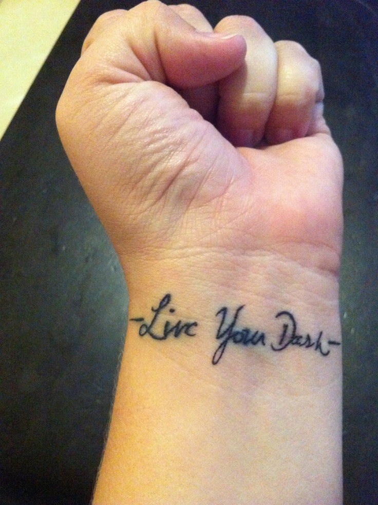 a person with a wrist tattoo that says live your dream on their left hand and the words are written in cursive writing