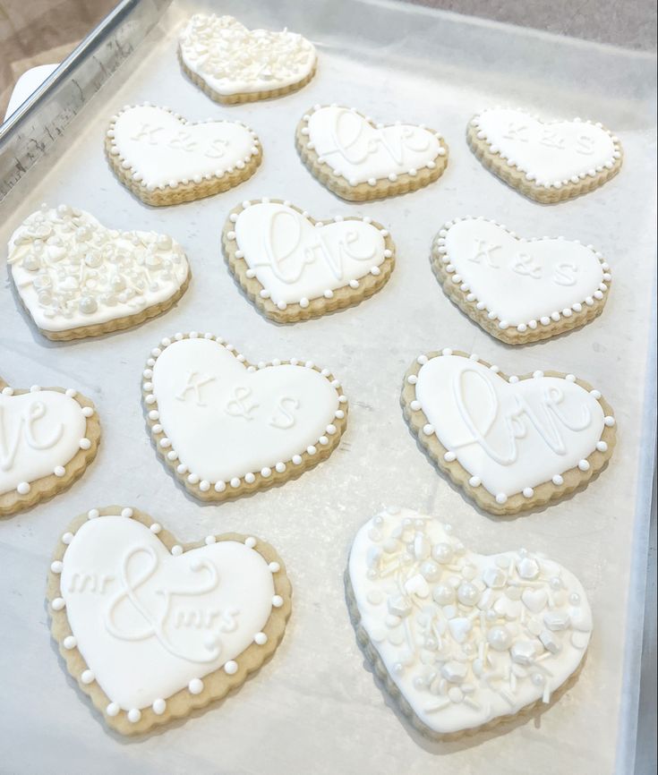 decorated cookies in the shape of hearts on a baking sheet