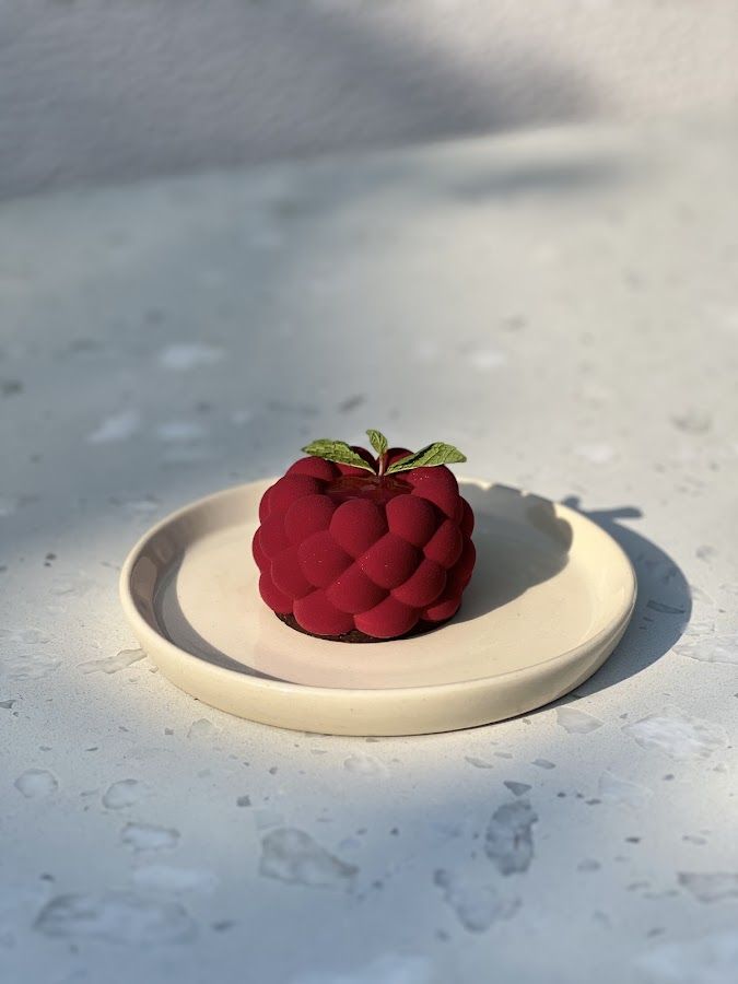 a red apple sitting on top of a white plate