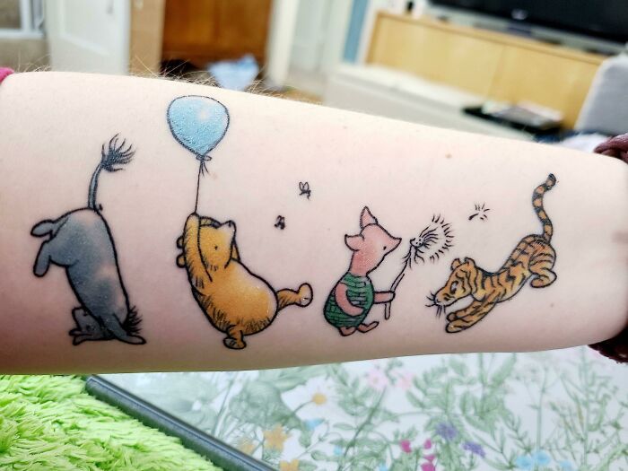 a woman's arm with winnie the pooh tattoos on it