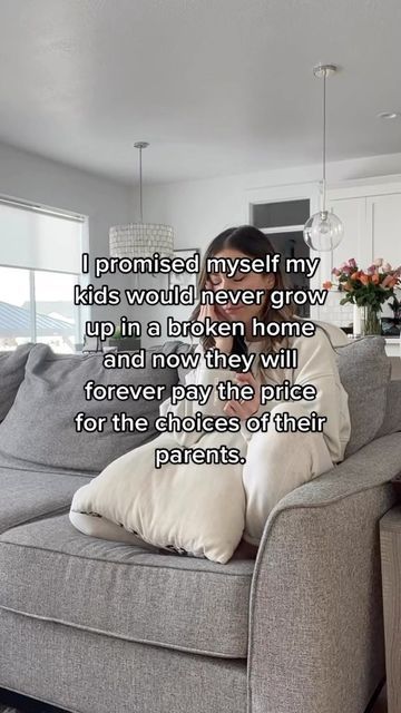 a woman sitting on top of a couch in a living room next to a window