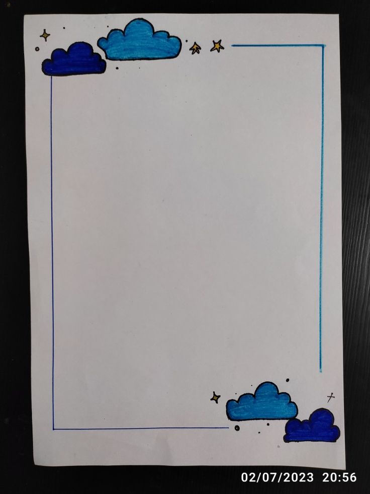 an empty paper with blue clouds and stars on the border is sitting on a table