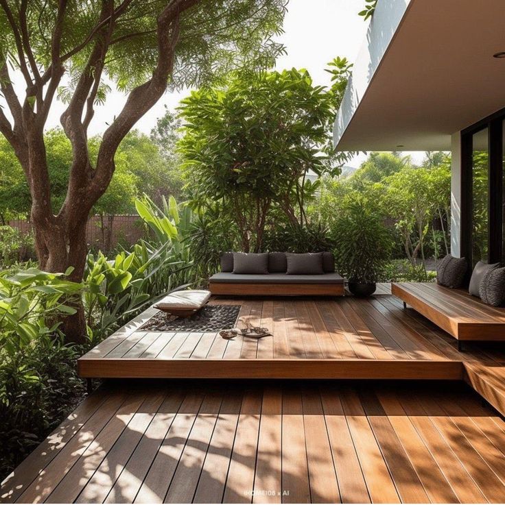 an outdoor living area with wood flooring and large plants on the side of it