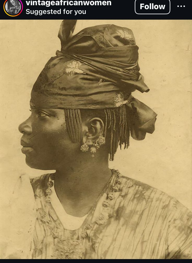 an old black and white photo of a woman wearing a turban with feathers on her head