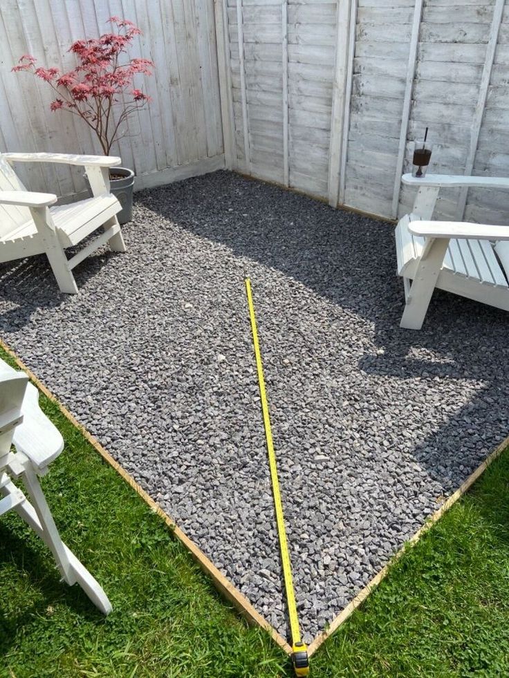 two white chairs sitting next to each other on top of a grass covered yard area