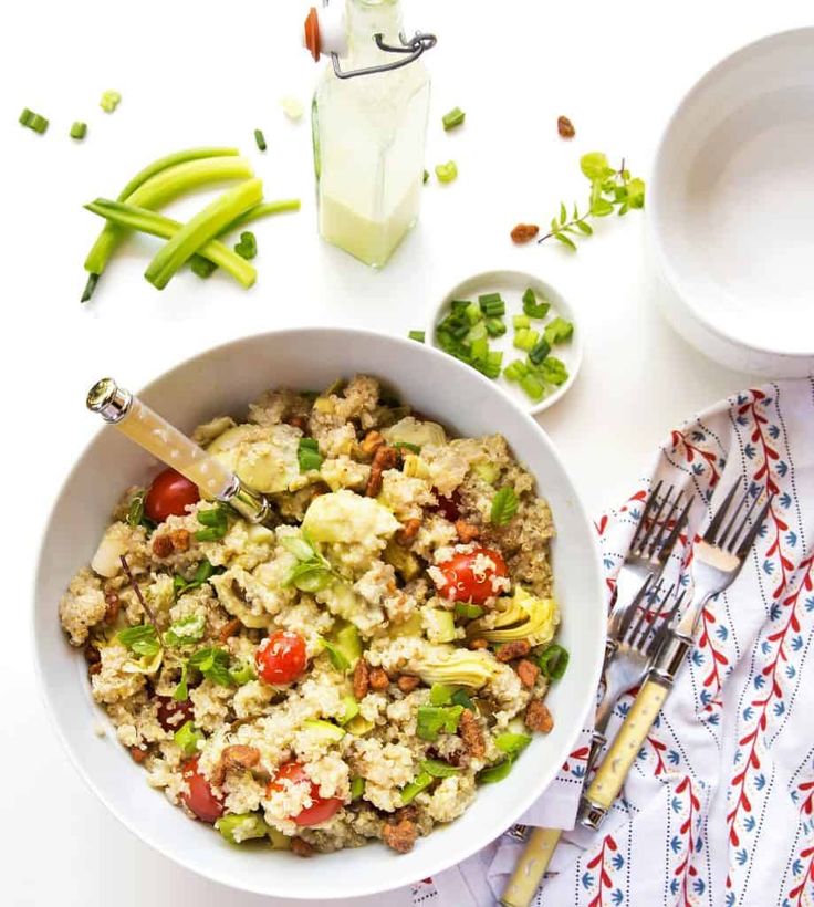 a white bowl filled with rice and vegetables next to two bowls of peas, celery