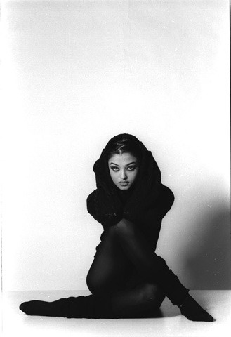 a black and white photo of a woman sitting on the floor