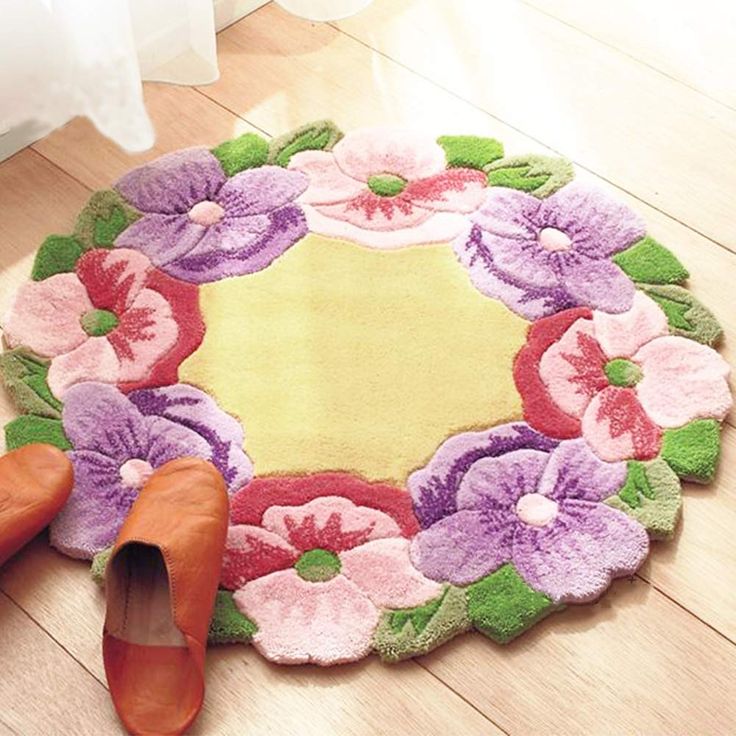 a pair of shoes sitting on the floor next to a rug with pink and purple flowers