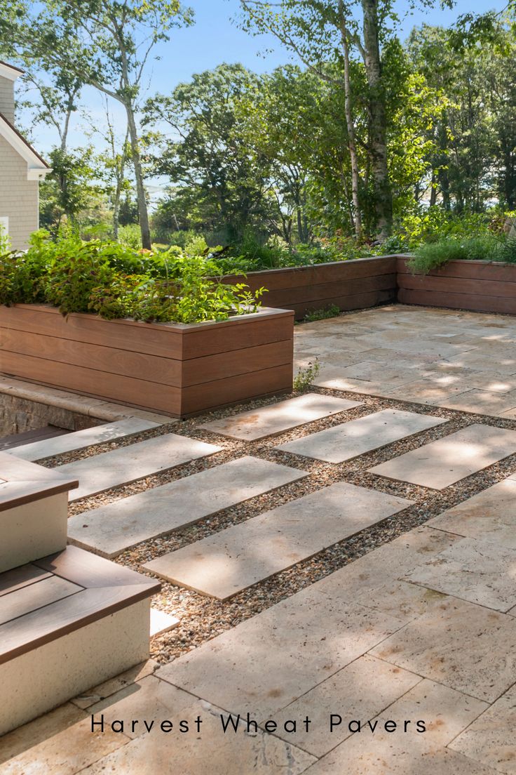 an outdoor patio with several planters and steps leading up to the back yard area