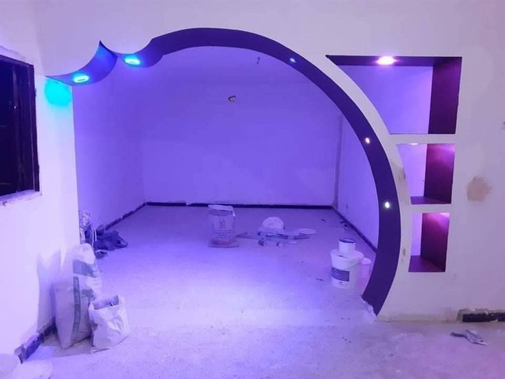 an empty room with purple lighting and white walls