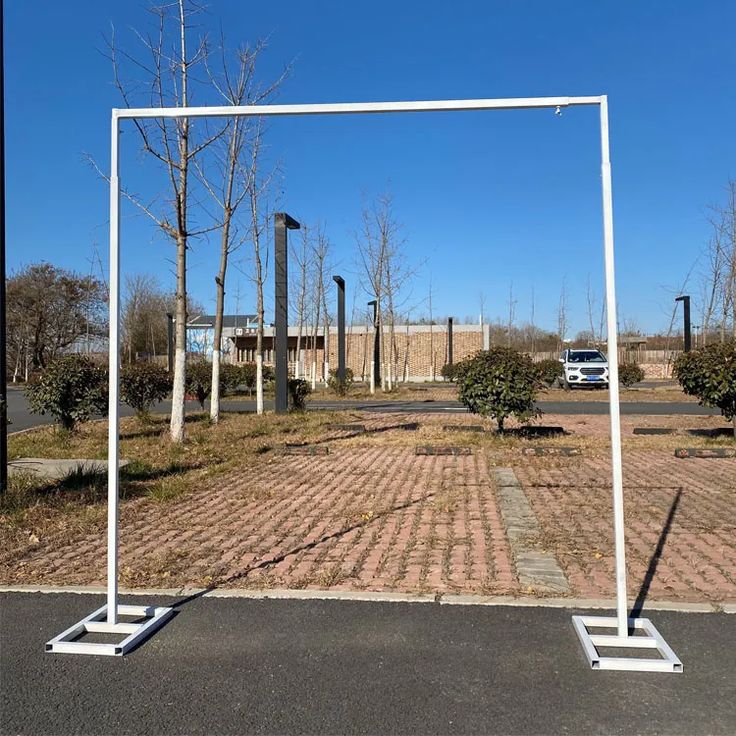 an empty parking lot with two white poles in front of it and a truck parked on the other side