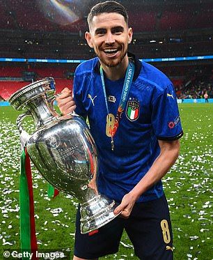 a man holding a silver trophy on top of a soccer field with confetti around his neck