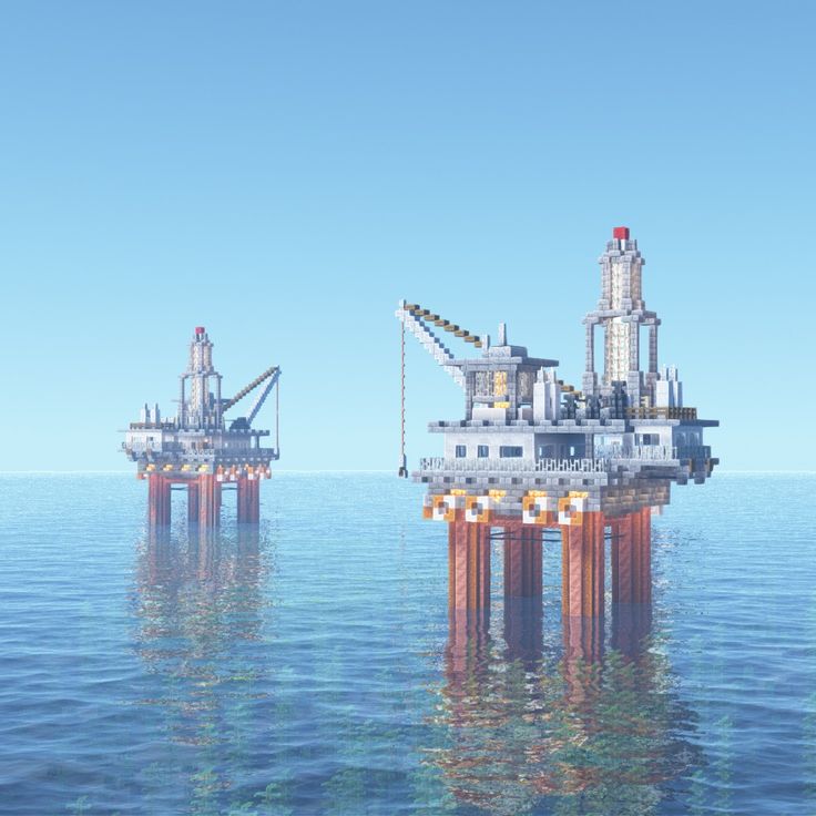 two oil rigs in the middle of the ocean with blue sky above them and water below