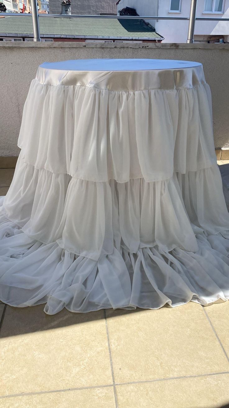 a white table with ruffled cloth on it