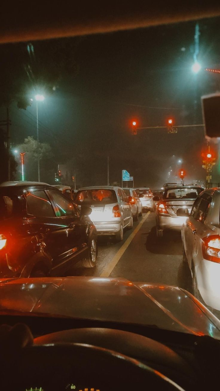 traffic is backed up at an intersection on a busy street during the night time,