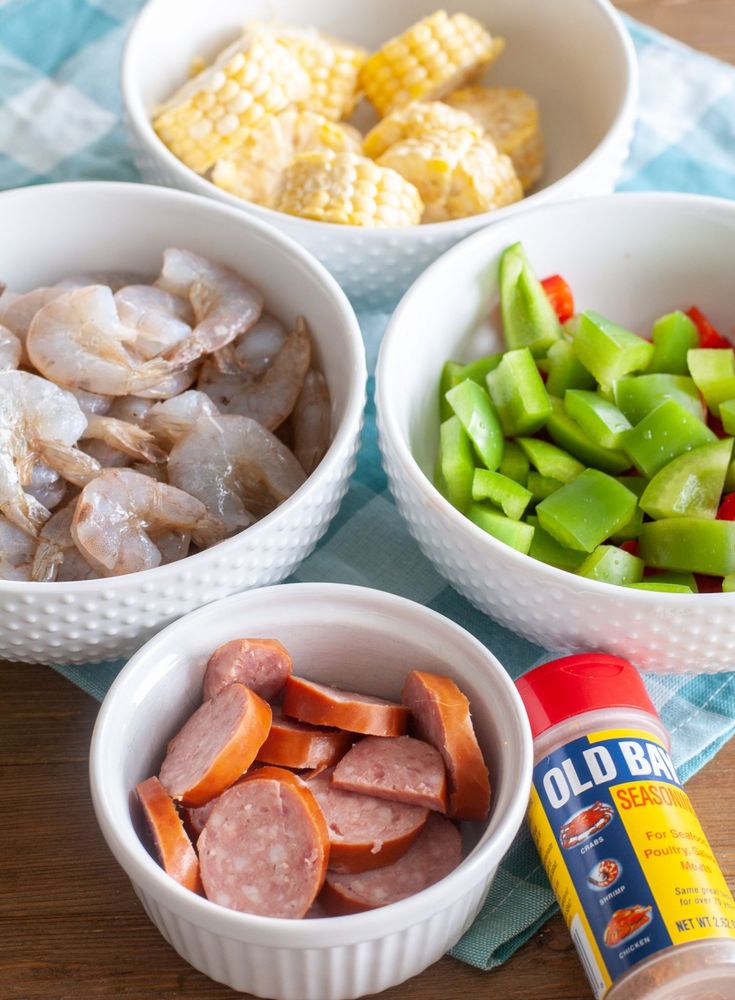 bowls filled with meat, vegetables and corn on the cob