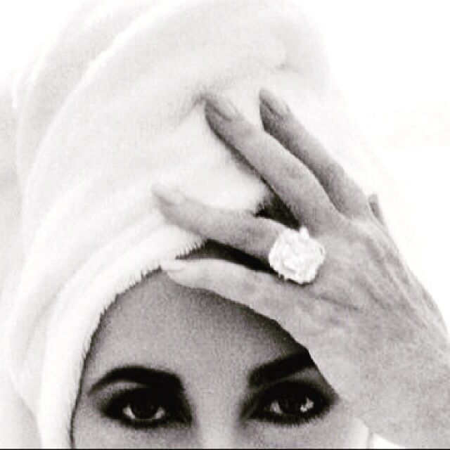 a woman with a towel on her head covering her eyes and hand over her face