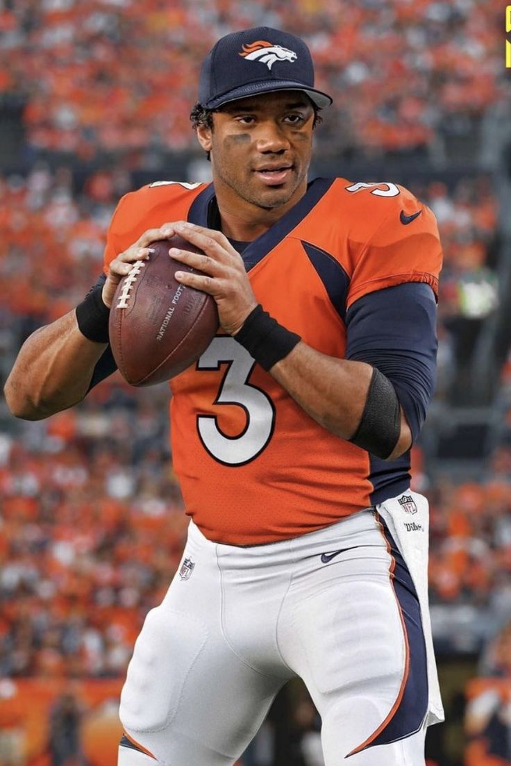 a man holding a football in his right hand and wearing an orange jersey with the number five on it