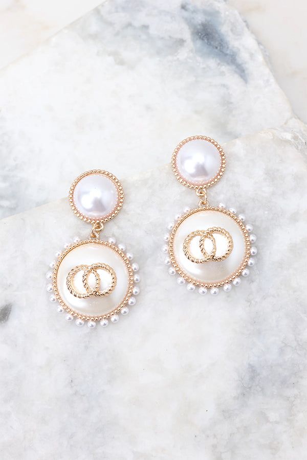 Look elegant and glamorous with these Graceful Glamour Pearl Earrings! These earrings put the “glam” in glamourous! Shine bright with these exquisite earrings and get ready to be the belle of the ball! These earrings feature pearl studs, gold detailing, small pearls circling larger pearl dangles, and a secure post backing. • Earrings measure 2" in length and 1" in width Chic Gold Clip-on Earrings With Pearl Drop, Feminine Pearl Earrings For Evening, Feminine Evening Pearl Earrings, Glamorous Pearl Earrings For Formal Occasions, Glamorous Pearl Drop Bridal Earrings, Elegant Party Jewelry With Pearl Buttons, Glamorous Formal Pearl Earrings, Chic Pearl Embellished Earrings For Evening, Party Pearl Earrings With Pearl Charm