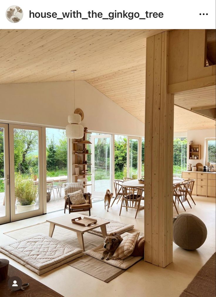 a living room filled with furniture next to sliding glass doors and a dog laying on the floor