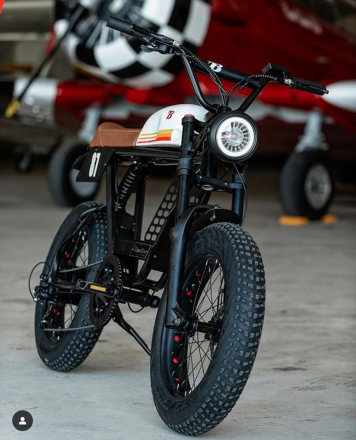 a small motorcycle parked next to an airplane