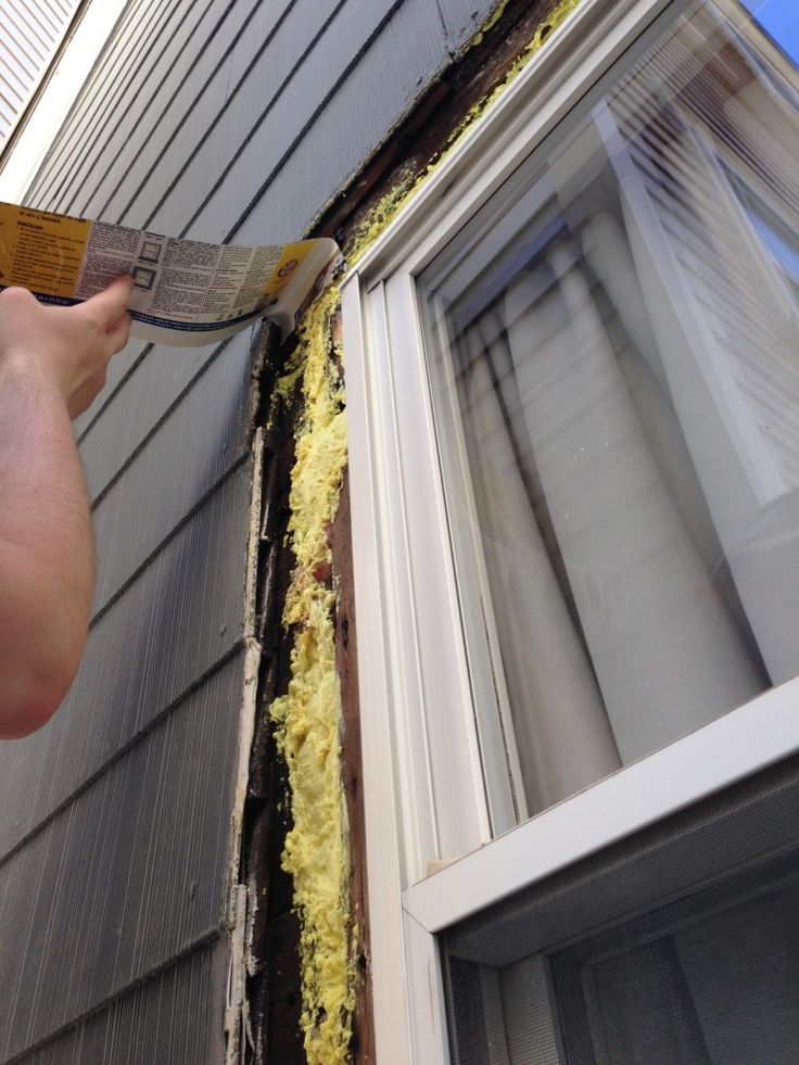 a man is painting the side of a house with yellow paint on it's walls