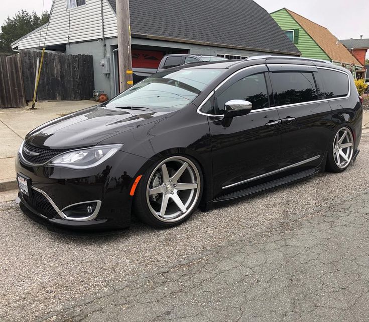 a black car parked in front of a house