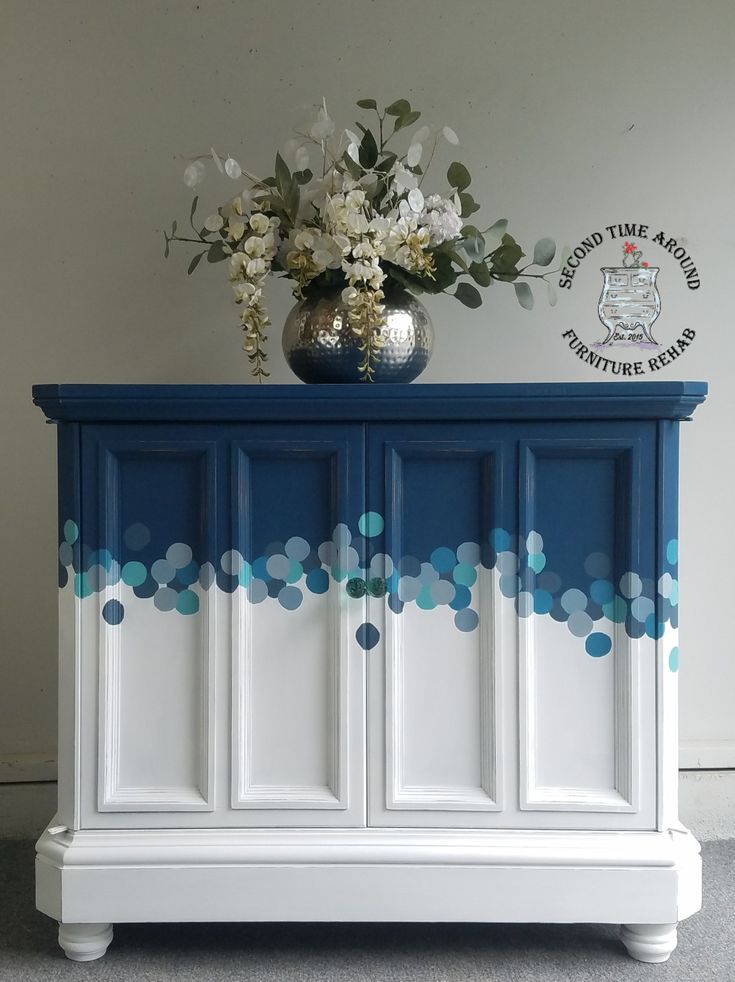 a blue and white cabinet with flowers on top