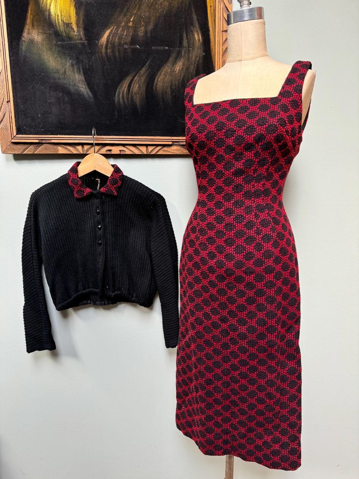 For your consideration is a lovely vintage 1950's dress and cropped knit cardigan set! No tags or labels, appears to be handmade and expertly done. The dress is a form-fitting wiggle dress with square neckline. The fabric is a black and red textured woven material that is really cool! I'm unsure of fiber content but it feels like an acrylic- possibly a wool blend. Bodice is lined in cotton but the bottom half of the dress is unlined. Back metal zipper.  The cardigan is a chunky acrylic knit with dolman sleeves and a collar to match the dress. Faceted black buttons down the front and an elastic bottom. Measurements: Size S/6 Dress: 36" chest 26" waist 36" hips 44" length Cardigan: 40" ptp 15" length Condition is excellent. No issues to note! Please see pics and ask any questions prior to pu Cropped Knit Cardigan, 1950's Dress, Dress With Square Neckline, Cardigan Set, Vintage 1950s Dresses, 1950s Dress, Wiggle Dress, Metal Zipper, Black Button