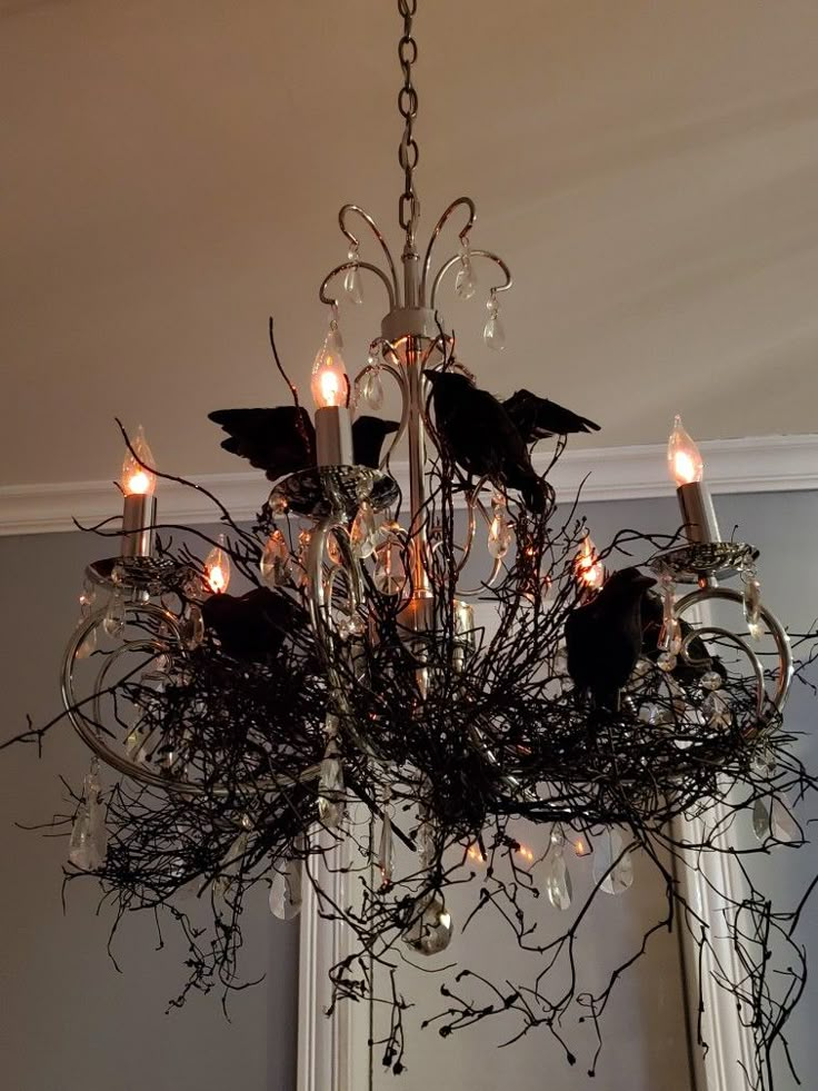 a chandelier with candles and branches hanging from it