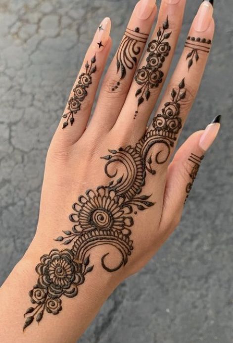 a woman's hand with henna tattoos on it