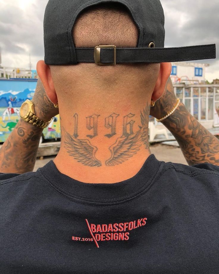 the back of a man's head with tattoos on it