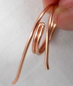 someone is holding some kind of metal object in their hand and it looks like they are making something out of copper wire