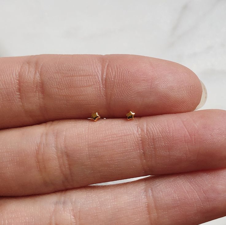 Teeny tiny minimalist star stud earrings-- looks great on its own or stacked with our other small studs! * 14k gold plating over sterling silver (hypoallergenic & nickel-free) * Matching post backing * Measures about 2mm * Ships as a pair (2 earrings total) Every order comes nicely packaged, ready for gift-giving! Please note that multiple items in the same order will be combined into one gift box. If the items are meant for separate individuals, please let me know. Also available in sterlin Basic Gold Earrings Studs, Cheap Minimalist Pierced Earrings, Gold Dainty Earrings Simple, Cheap Tiny White Piercings, Cheap Nickel-free Dainty Piercings, Small Minimalistic Earrings, Small And Simple Earrings, Cute Small Cheap Earrings, Minimalist Earrings Studs Simple