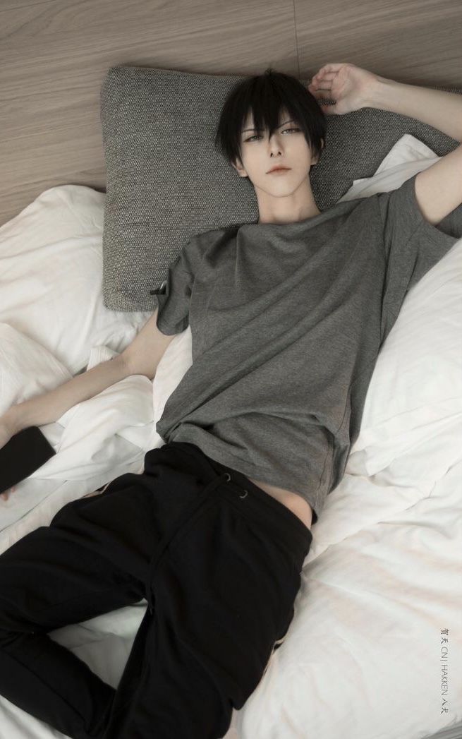 a young man laying on top of a bed