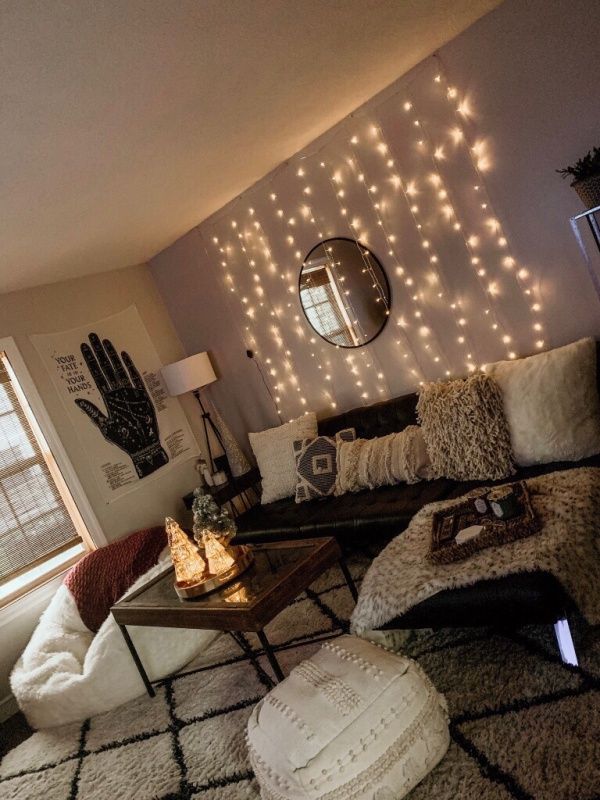 a living room filled with lots of furniture and lights on the wall above it's windows