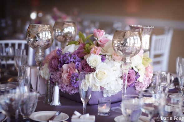 the table is set with silverware and flowers in vases, plates and glasses