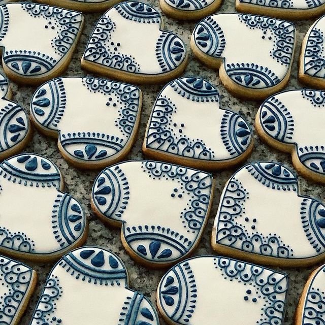 many decorated cookies on a table with blue and white designs