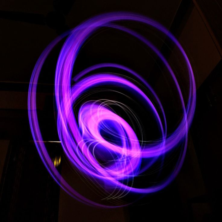 a blurry photo of a purple object in the dark, with light streaks on it